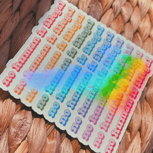 colorful "no human is illegal" sticker  |  holographic rainbow sticker (CHIRLA collection)