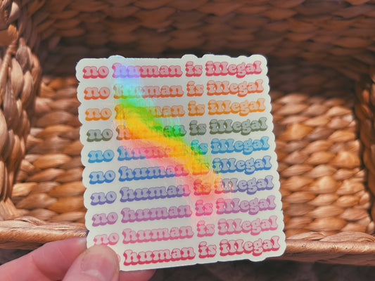 colorful "no human is illegal" sticker  |  holographic rainbow sticker (CHIRLA collection)