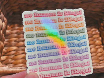 colorful "no human is illegal" sticker  |  holographic rainbow sticker (CHIRLA collection)